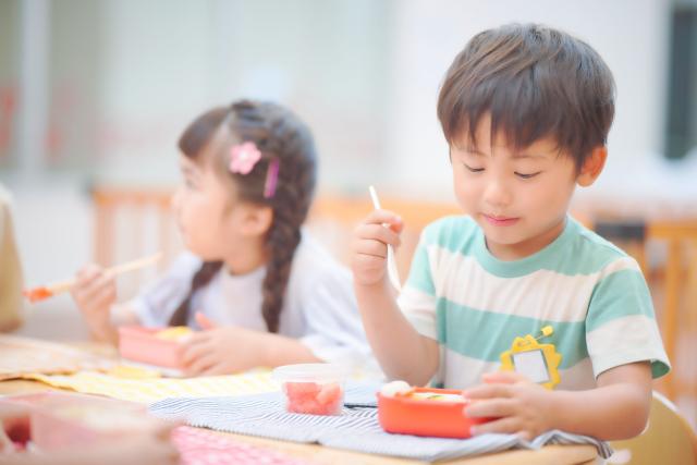 幼稚園でお弁当を食べる子ども